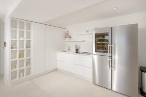 a kitchen with white cabinets and a stainless steel refrigerator at Villa Marina Hvar in Hvar