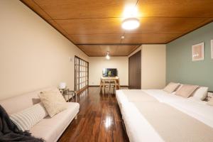 a living room with two white couches and a table at Staylinks Nara Kitamachi in Nara