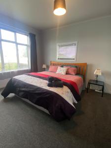 a bedroom with a bed with a cat laying on it at Marvellous on Maggie in Invercargill