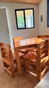 a wooden dining table and chairs with a window at Bambito´s Café & Hostel in Cerro Punta