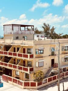 an apartment building with a balcony on top of it at Caye Caulker Plaza Hotel in Caye Caulker