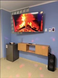 a flat screen tv on a wall with a fireplace at Peruyork - Sauna & Jacuzzi in Chiclayo