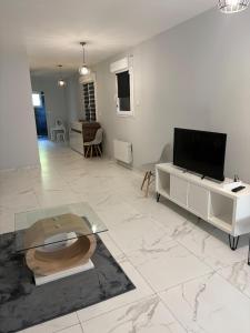 a living room with a television and a table at Maison perthois in Saint-Dizier
