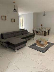 a living room with a black couch and a table at Maison perthois in Saint-Dizier