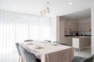 a dining room with a table with chairs and a kitchen at Sun & Salt Villa in Alvor