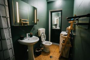 a bathroom with a sink and a toilet and a mirror at Tirana SkyView in Tirana +65 photos