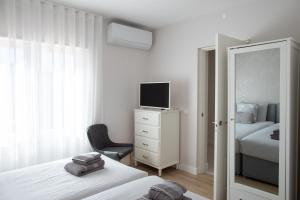 a bedroom with a bed and a tv and a mirror at Sun & Salt Villa in Alvor +48 photos