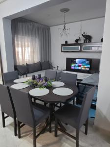 a dining room with a black table and chairs at Rosemary Guesthouse in Kavála