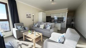 a living room with a couch and chairs and a table at Face a l'océan, vue panoramique, 3 min a pied de la plage, Praia da areia branca in Praia da Areia Branca