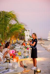 a woman standing in front of a table on the beach at BijBlauw in Willemstad