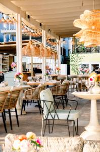 a restaurant with tables and chairs and lights at BijBlauw in Willemstad