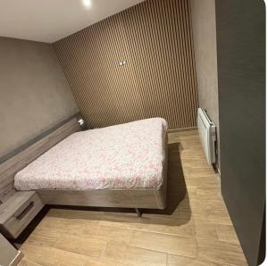 a small bed in a corner of a room at Logement centre ville in Saint-Dizier