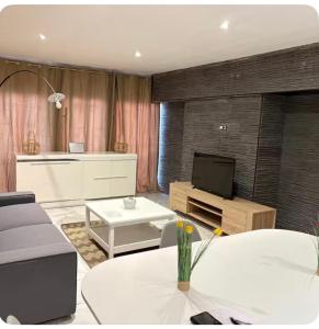 a living room with a couch and a television at Logement centre ville in Saint-Dizier