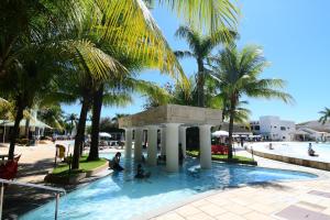 a pool at a resort with palm trees at Lacqua diRoma 1 - Apartamentos JN in Caldas Novas