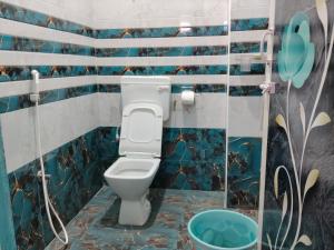 a bathroom with a toilet with blue tiled walls at Auro Delight - Near Auroville in Pondicherry in Villupuram +23 photos