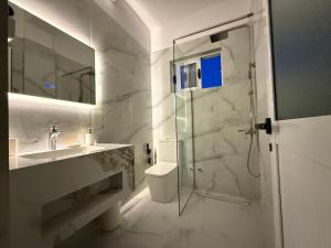 a bathroom with a shower and a sink and a toilet at Apartments Vila Ardi in Sarandë +35 photos