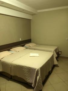 two beds in a room with two beds sidx sidx sidx at Hotel Paranoá in Jabuticabal