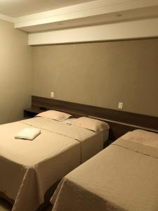 a room with three beds in a room at Hotel Paranoá in Jabuticabal