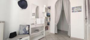 a white room with a shelf with books at CAPERCIA home in Forio d'Ischia