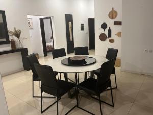 a dining room with a table and black chairs at Villa Abou in Assinie