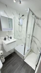 a white bathroom with a shower and a sink at Suite 2 En-suite Room with Double Bed in Edinburgh