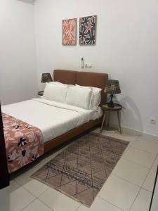 a bedroom with a bed and a table with a lamp at Villa Abou in Assinie