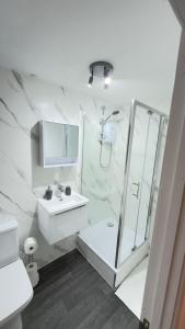 a white bathroom with a shower and a sink at Suite 2 En-suite Room with Double Bed in Edinburgh