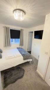 a bedroom with a large bed and a chandelier at Suite 2 En-suite Room with Double Bed in Edinburgh