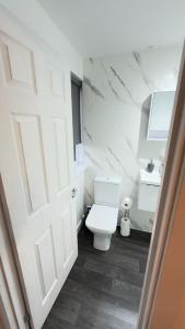a bathroom with a white toilet and a sink at Suite 2 En-suite Room with Double Bed in Edinburgh