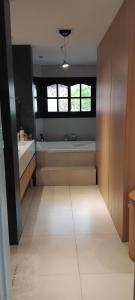 a large bathroom with a bath tub and a window at VICTORIA 3 BED AND BREAKFAST A 3KM DEL AEROPUERTO EZEIZa in Ezeiza