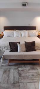 a large bed with pillows on top of it at VICTORIA 3 BED AND BREAKFAST A 3KM DEL AEROPUERTO EZEIZa in Ezeiza