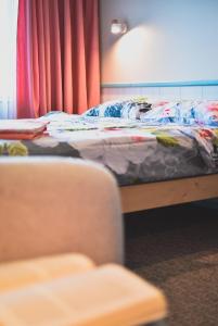 a bedroom with a bed and a chair next to it at Metsa Hostel in Võsu