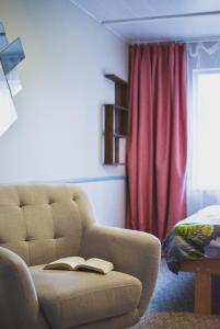 a living room with a couch with a book on it at Metsa Hostel in Võsu