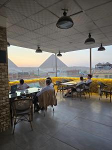 a group of people sitting at tables in a restaurant at nova pyramids inn in Cairo