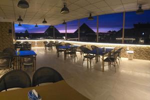 a restaurant with tables and chairs with a view at nova pyramids inn in Cairo