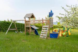 a wooden playground with a slide and a ladder at Villa Swarzewo in Swarzewo +19 photos