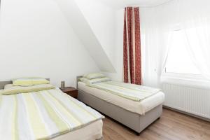 two beds in a small room with a window at Villa Swarzewo in Swarzewo