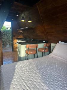 a bedroom with two chairs and a bed and a kitchen at Pousada Gravatá in Gravatal +86 photos
