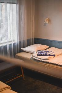 two twin beds in a room with a window at Metsa Hostel in Võsu +32 photos