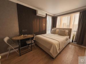 a bedroom with a bed and a table and a window at RentHouse Apartments Panoramic-Airport-Studio in Chişinău