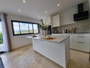 a kitchen with white cabinets and a large window at Apt Belvedere in Apt