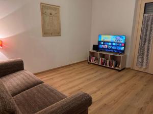 a living room with a couch and a flat screen tv at Il Respiro del Brenta in San Lorenzo in Banale