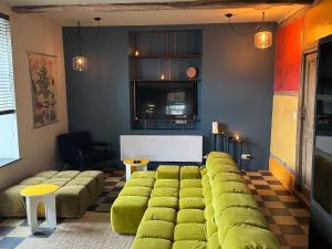 a living room with a large green couch at L' Ecole in Durbuy