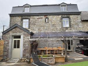 a stone house with a table in front of it at L' Ecole in Durbuy