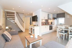 a living room with a couch and a table and a kitchen at Kleine-Auszeit in Greetsiel