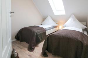 two beds in a small room with a window at Kleine-Auszeit in Greetsiel