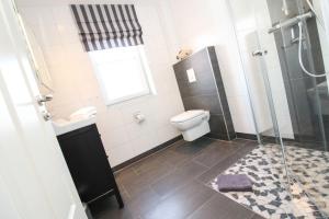 a bathroom with a toilet and a glass shower at Kleine-Auszeit in Greetsiel +16 photos