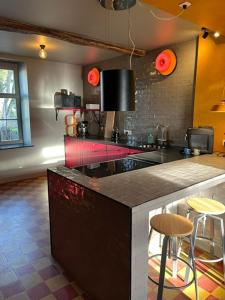 a kitchen with a counter and some stools in it at L' Ecole in Durbuy