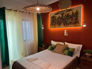 a bedroom with a bed with a painting on the wall at Kaz An Nou in Cotonou