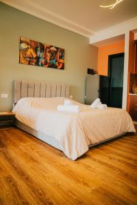 a large bed in a room with a wooden floor at Tirana SkyView in Tirana